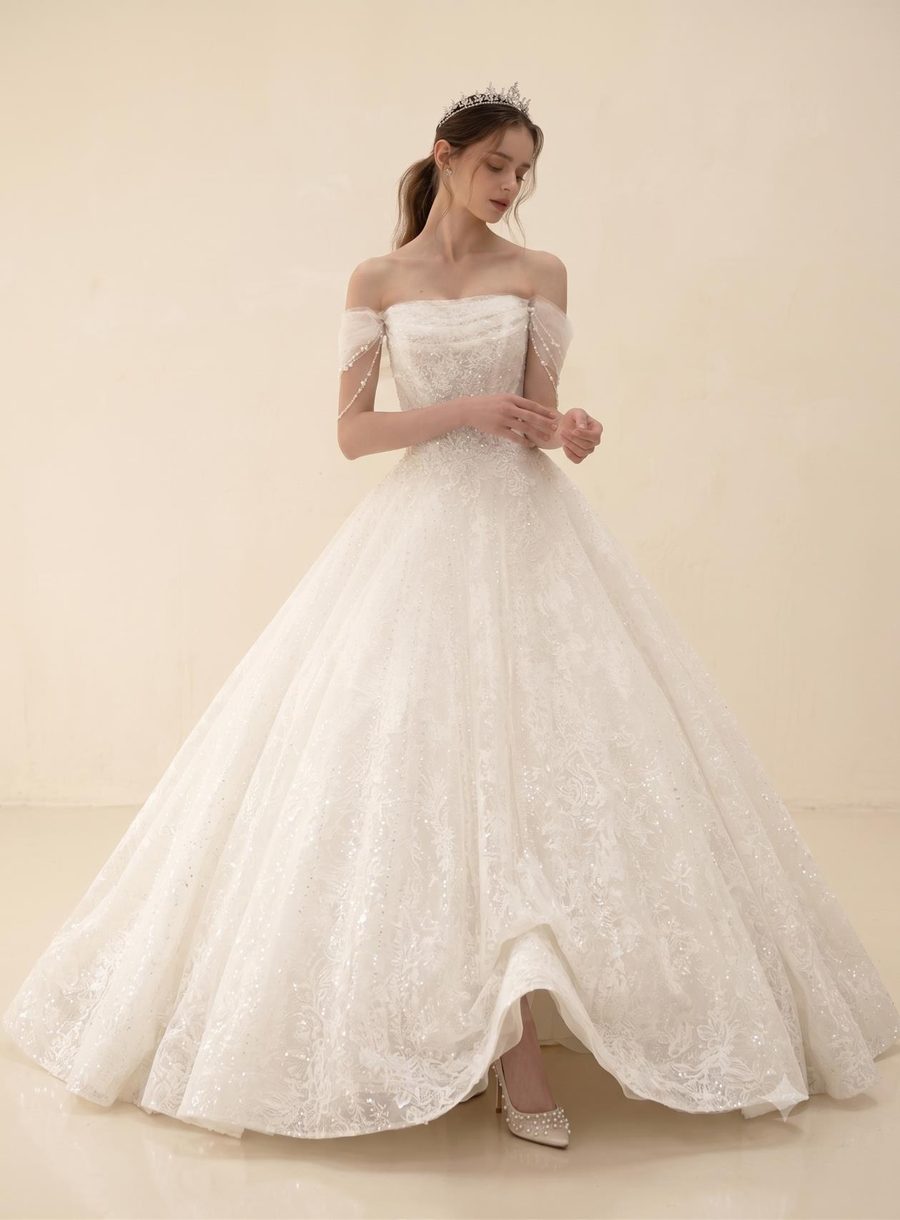 Style 26·04 — draped off-shoulder gown with pearl lace bodice